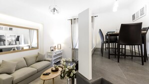 Un salon moderne comprenant un canapé, une table basse et un coin repas avec des chaises et une table.