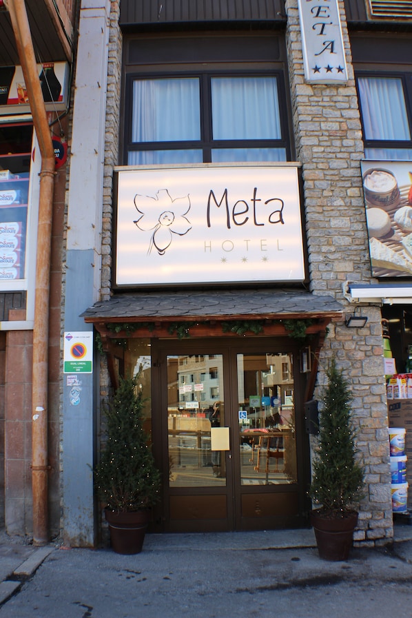 Un hotel llamado "Meta Hotel" con un letrero que presenta un diseño floral.