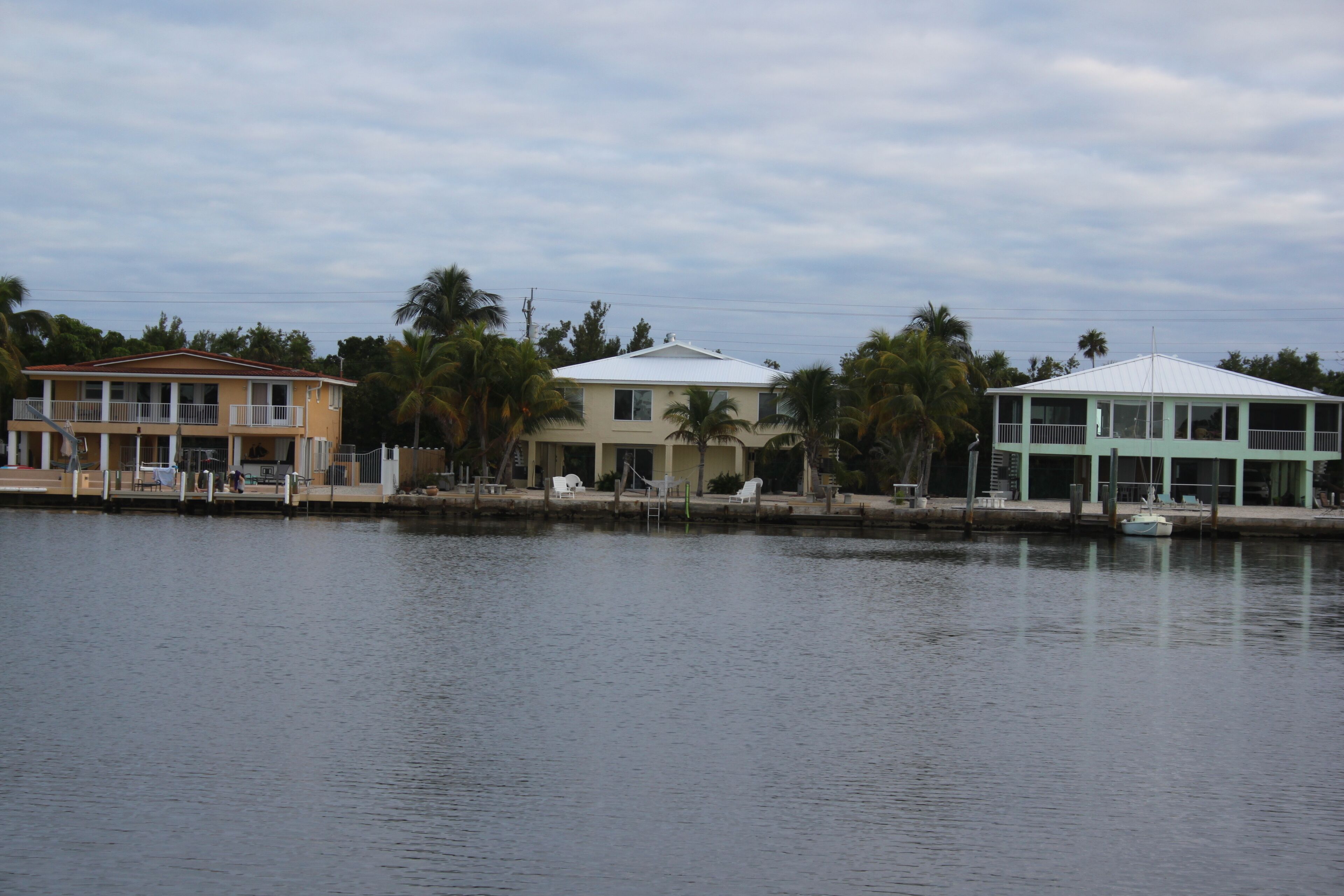 A waterfront property with a two-story building, a dock, and a small boat.