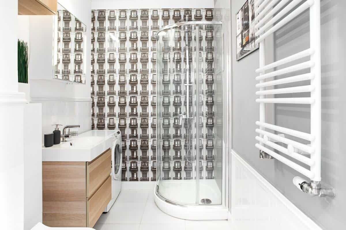 Un bagno moderno con doccia, lavandino e water.