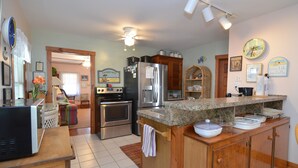 A kitchen with stainless steel appliances, wooden cabinets, and a granite countertop.