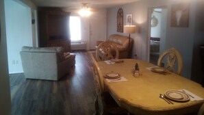 A dining area with a table set for four, a sofa, and a chair. - Relaxing fishing and hunting getaway 1 bock from the water (Port Mansfield)