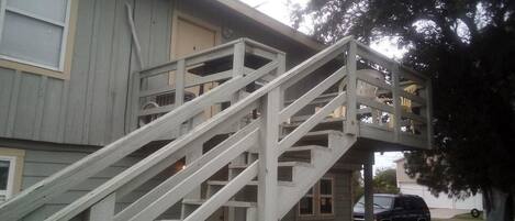 Un bâtiment à deux étages avec un escalier en bois menant à un balcon.