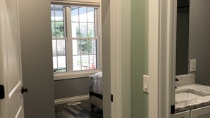 A hallway leading to a bedroom with a window, a bathroom with a sink, and a door. - Located at Silver Lake with access to Silver Lake and sand dunes. (Mears)