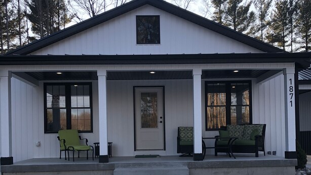 A two-story house with a front porch, a door, and a small window above the door. - Located at Silver Lake with access to Silver Lake and sand dunes. (Mears)