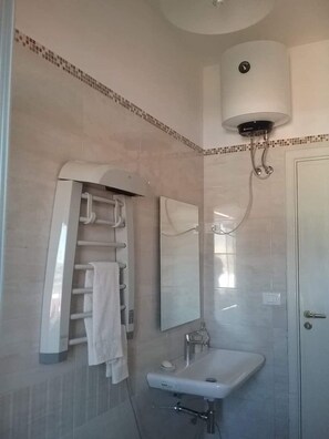 A bathroom with a towel rack, a sink, a mirror, and a toilet. - Atmosphere (in the city center) (Cosenza)