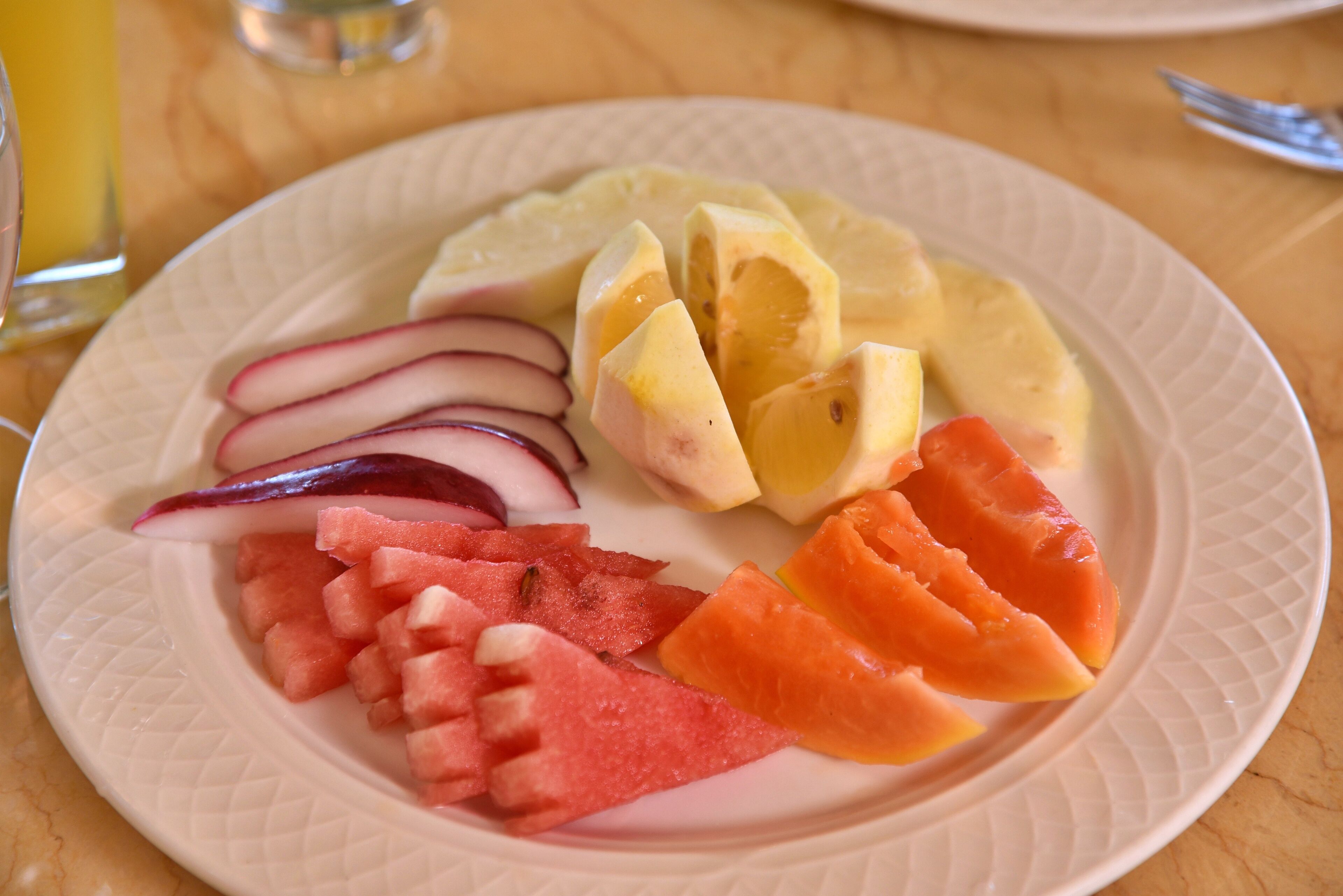 Une assiette de fruits coupés en tranches, notamment de la pastèque, du melon et des radis.