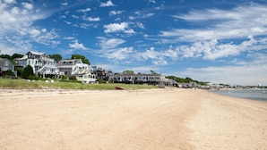 A beach with a row of houses along the shore, a sandy beach, and a clear blue sky. - Beachfront, East End, 2 BR, 2BA, Private Deck, Parking, Dog Friendly (Provincetown)