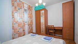 Makuuhuone, jossa on sänky, työpöytä, tuoli ja vaatekaappi.