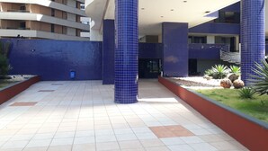 Un bâtiment moderne avec des colonnes recouvertes de carreaux bleus et un sol carrelé.