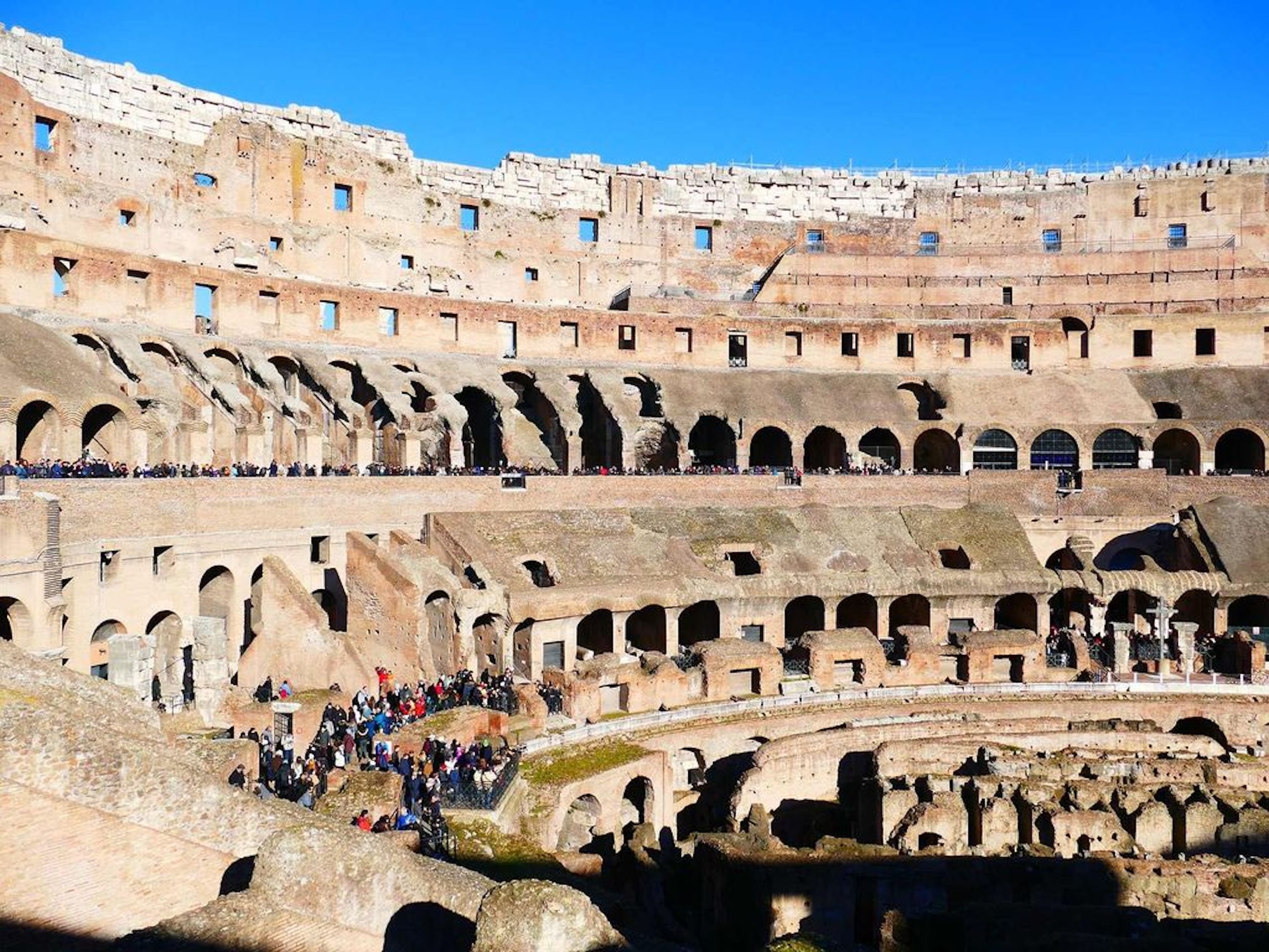 Un amphithéâtre antique, doté de plusieurs niveaux de gradins, où une foule s’était rassemblée dans la partie inférieure.