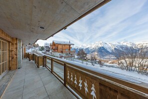 A wooden balcony with a view of snow-covered mountains and a clear sky. - Nendaz 2 bedroom apartment - close ski lift (R27) (Haute-Nendaz)