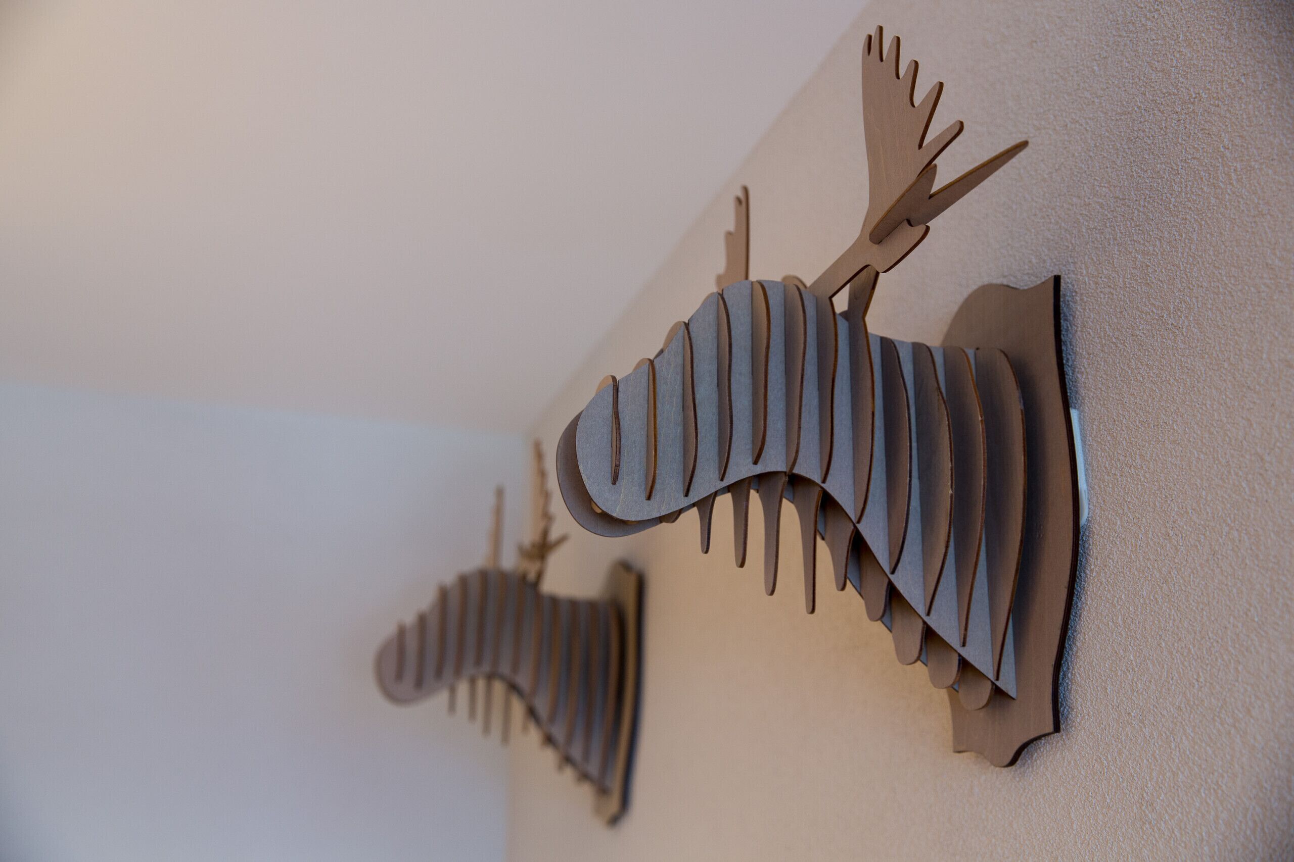 A wall-mounted wooden sculpture of a moose.