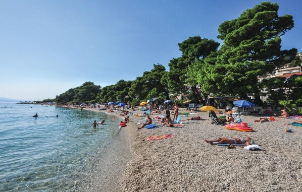 Guests can enjoy the beach with umbrellas and shade from the trees.