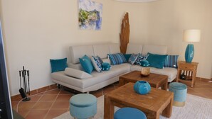 Ein Wohnzimmer mit Sofa, Couchtisch, Hocker und Lampe.