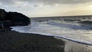A rocky coastline with waves crashing onto the shore.