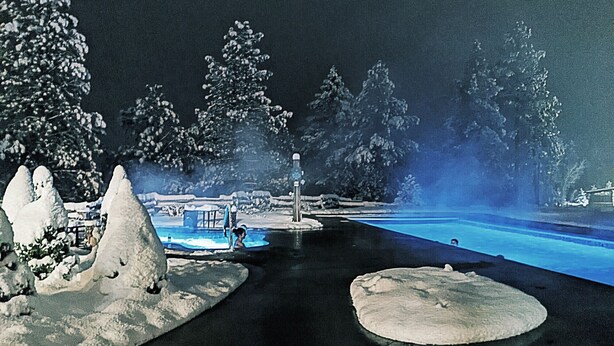 A nighttime scene with a pool area, snow-covered landscape, and trees. - Large newly updated condo in close proximity to town and summer adventures!  (Durango)