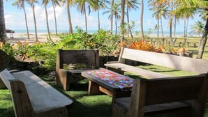 A wooden bench and table set outdoors with a view of the beach and palm trees. - Paraiso in Bahia - house by the sea in the middle of coconut trees (Belmonte)
