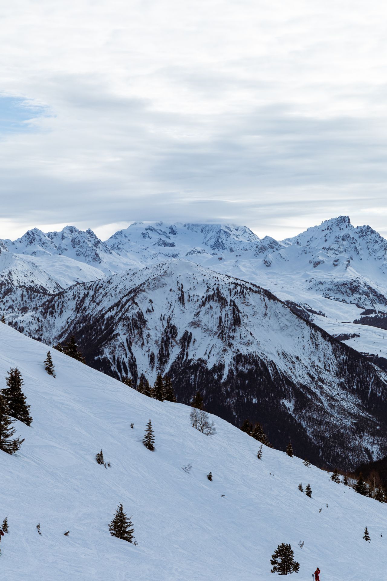 Un paysage de montagne enneigé avec une piste de ski.