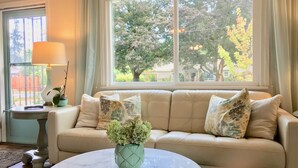 A living room with a beige sofa, a round marble coffee table, and a potted plant. - Cottage near Vancouver Lake! Cozy, Clean, & Comfortable w/ new Pickleball Court! (Vancouver)
