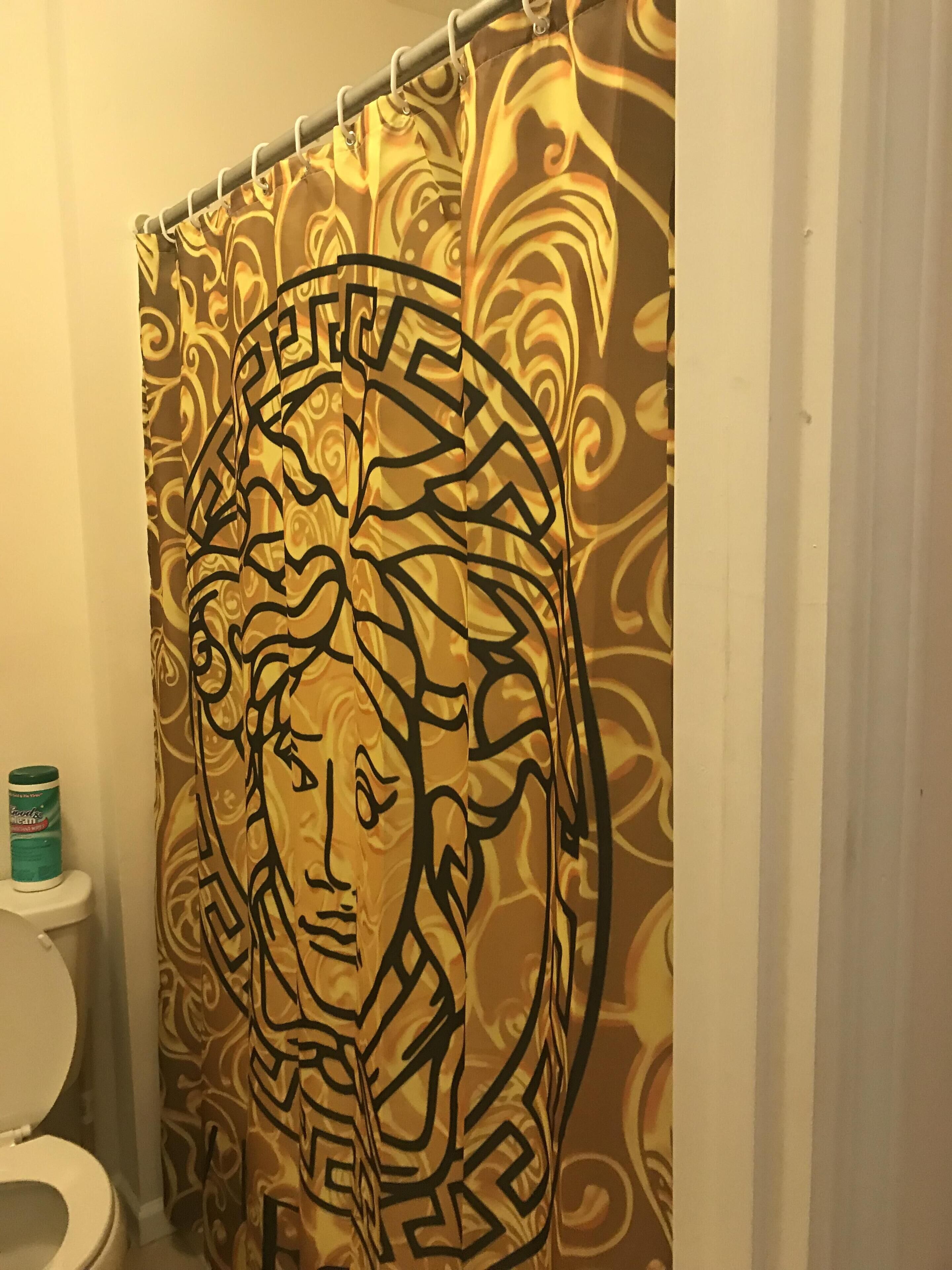 Une salle de bain avec un rideau de douche orné d’un motif géométrique.