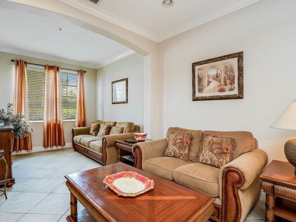 A living room with a sofa set, a wooden coffee table, and a framed picture on the wall.