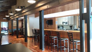 A spacious restaurant with wooden floors, high ceilings, and bar stools. - Chimney Hill Mtn Chalet w/resort access - heated pools, trails, near lake & town (Wilmington)