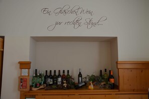 A wine rack with various bottles and a decorative sign above it.