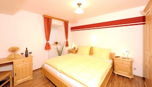 A bedroom with a bed, wooden nightstands, a dresser, and a mirror. - Standard Double Room - Kirchenwirt Aigen (Aigen im Ennstal)