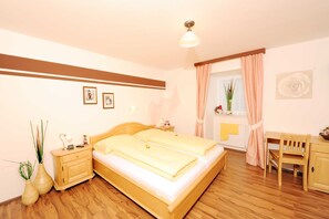 Une chambre à coucher avec un lit en bois, des tables de chevet, un bureau et une chaise.