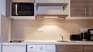 A compact kitchen with a microwave, a coffee maker, a toaster, and a washing machine. - Renovated studio for 4 people with washer, wifi (Brides-les-Bains)