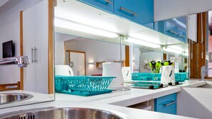 A modern kitchen with a stainless steel sink, white countertops, and blue cabinets. - 2* Studio with Wifi in Brides-les-Bains Center (Brides-les-Bains)