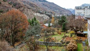 Un paisaje montañoso con un pueblo y un edificio grande con varias ventanas.