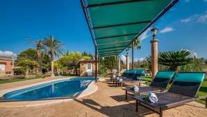 A poolside area with lounge chairs, a covered seating area, and a clear view of the pool. - Finca in Mallorca Can Caragol Inca with pool (Inca)