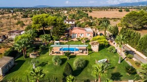 A large house with a swimming pool, surrounded by lush greenery and palm trees. - Finca in Mallorca Can Caragol Inca with pool (Inca)