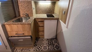 A compact kitchen with a microwave, sink, and small refrigerator. - Studio for 4 - City Center, Balcony, Wi-Fi (Brides-les-Bains)
