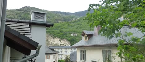 Et boligområde med huse, en trappe og udsigt til en grøn skråning.
