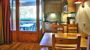 A compact kitchen with wooden cabinets, a microwave, and a sink. - Cozy Studio with WiFi and Parking - Sleeps 4 (Brides-les-Bains)