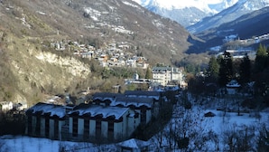 A mountainous village with snow-covered houses and a prominent building with a large window. - 2* Studio for 4 with mountain view, parking included, pets allowed (Brides-les-Bains)