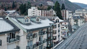A hotel with multiple floors, balconies, and a view of a mountainous landscape.