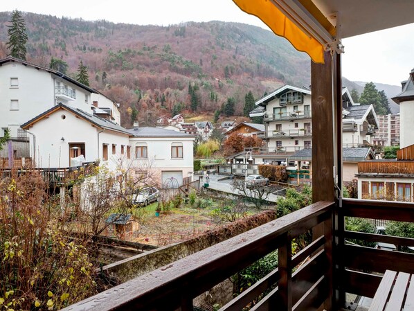 A balcony with a view of a residential area, including houses and a hillside. - Bright apartment in Brides, 6 pax, balcony, wifi, pets allowed (Brides-les-Bains)