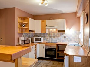 A compact kitchen with white cabinets, a microwave, toaster, and oven. - Bright apartment in Brides, 6 pax, balcony, wifi, pets allowed (Brides-les-Bains)