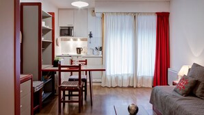 Ein kompakter Wohnraum mit Küchenzeile, Essbereich und Schlafzimmer.