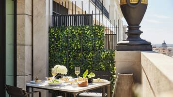 Un espace de restauration en plein air avec une table dressée pour un repas, entouré de verdure et agrémenté d’un vase décoratif.