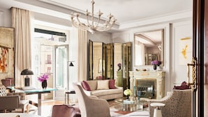 A spacious living room with a fireplace, comfortable seating, and a large mirror. - Four Seasons Hotel Madrid (Madrid)
