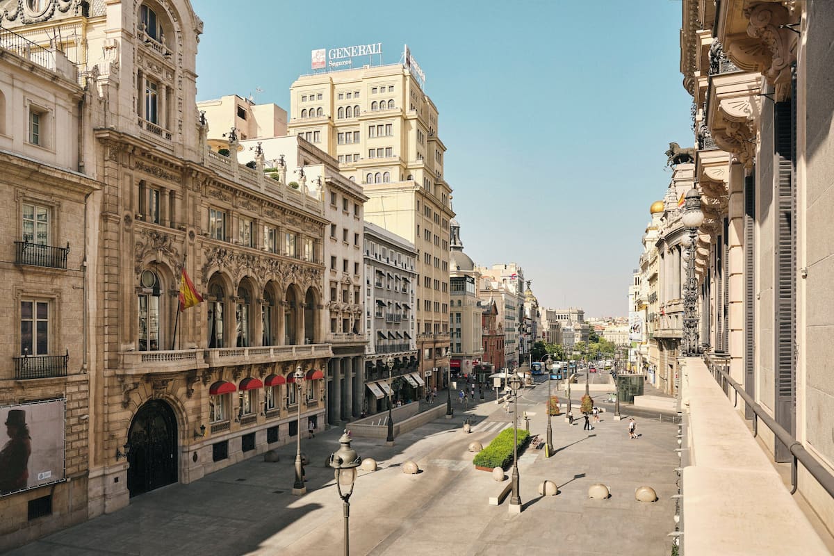 Una amplia plaza abierta con arquitectura clásica, incluyendo fachadas ornamentadas y un edificio destacado con un letrero que dice "Generali".