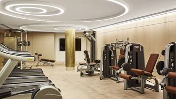 A gym with treadmills, weight machines, and a large pillar.