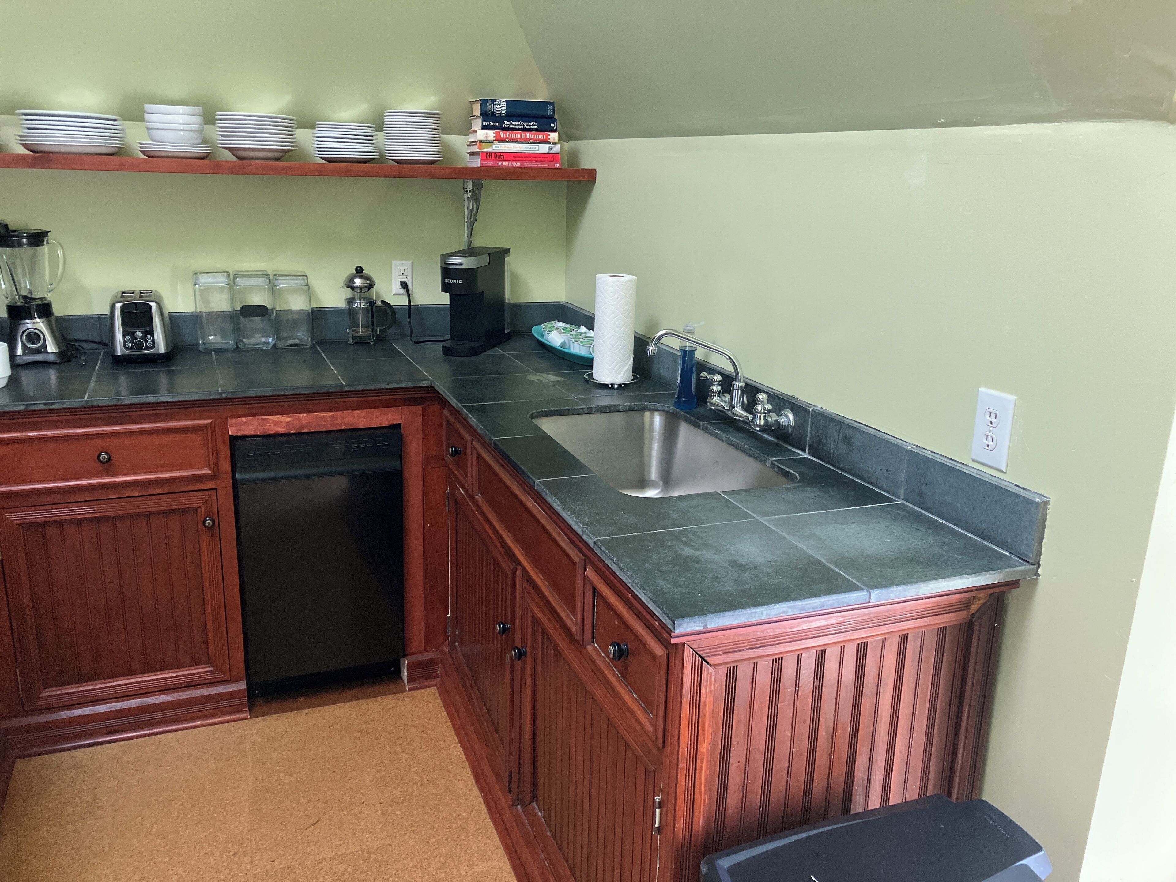 Una cocina equipada con lavavajillas, cafetera y un lavabo.