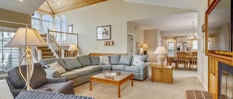 A spacious living room with a sectional sofa, a coffee table, and a fireplace.