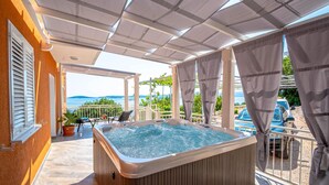 A hot tub on a covered patio with a view of the sea. - 3 bedroom lovely apartment in Orebic (Orebic)